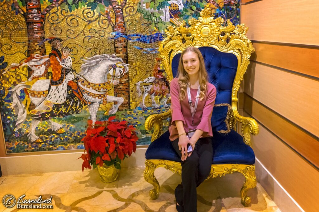 Katie sits in the royal chair off to the side of the Lobby Atrium.