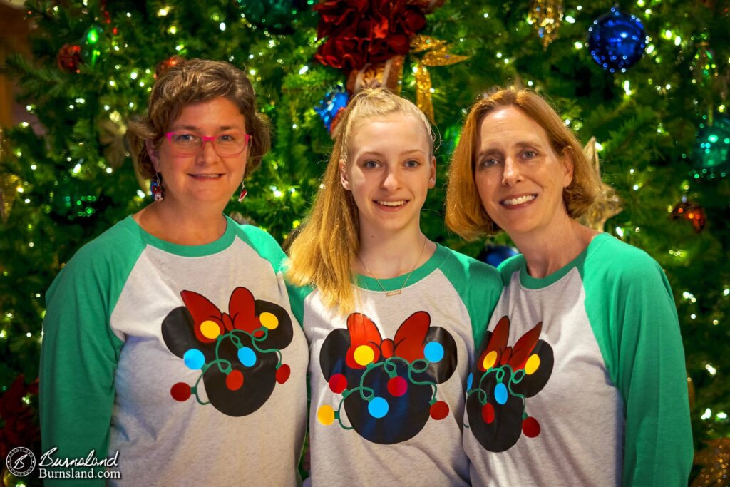 Girls in matching shirts in front of the Christmas tree