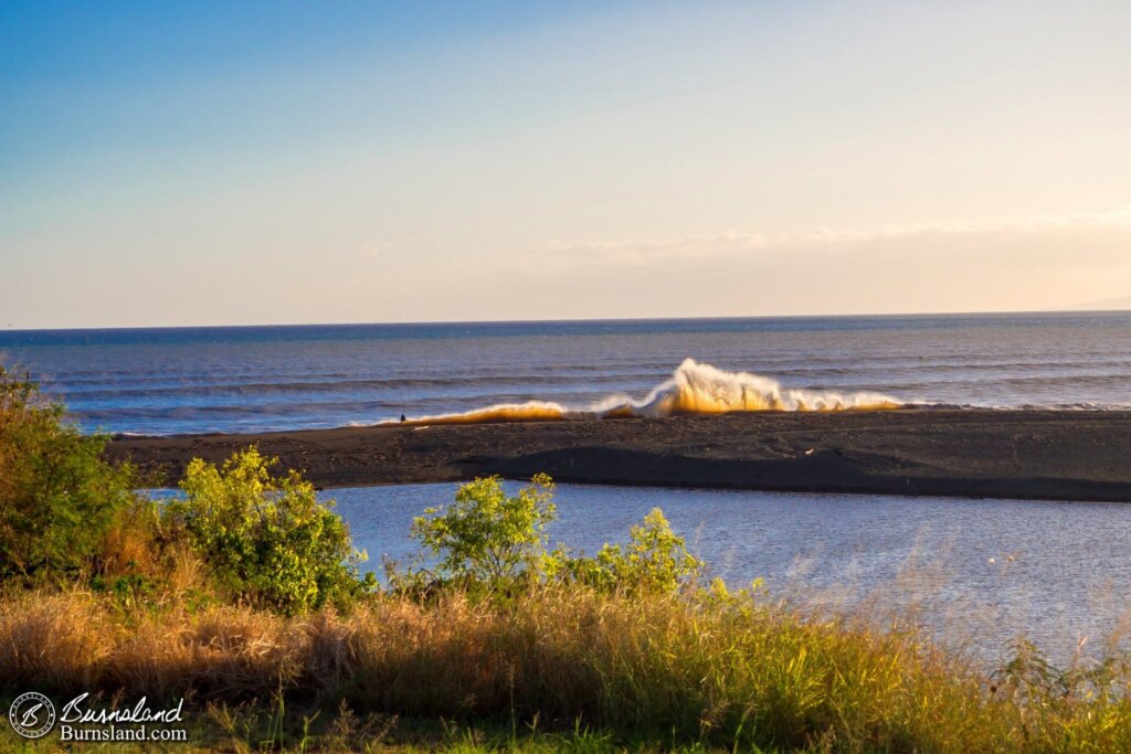 Waves crash onto a bank where the Waimea River meets the Pacific Ocean