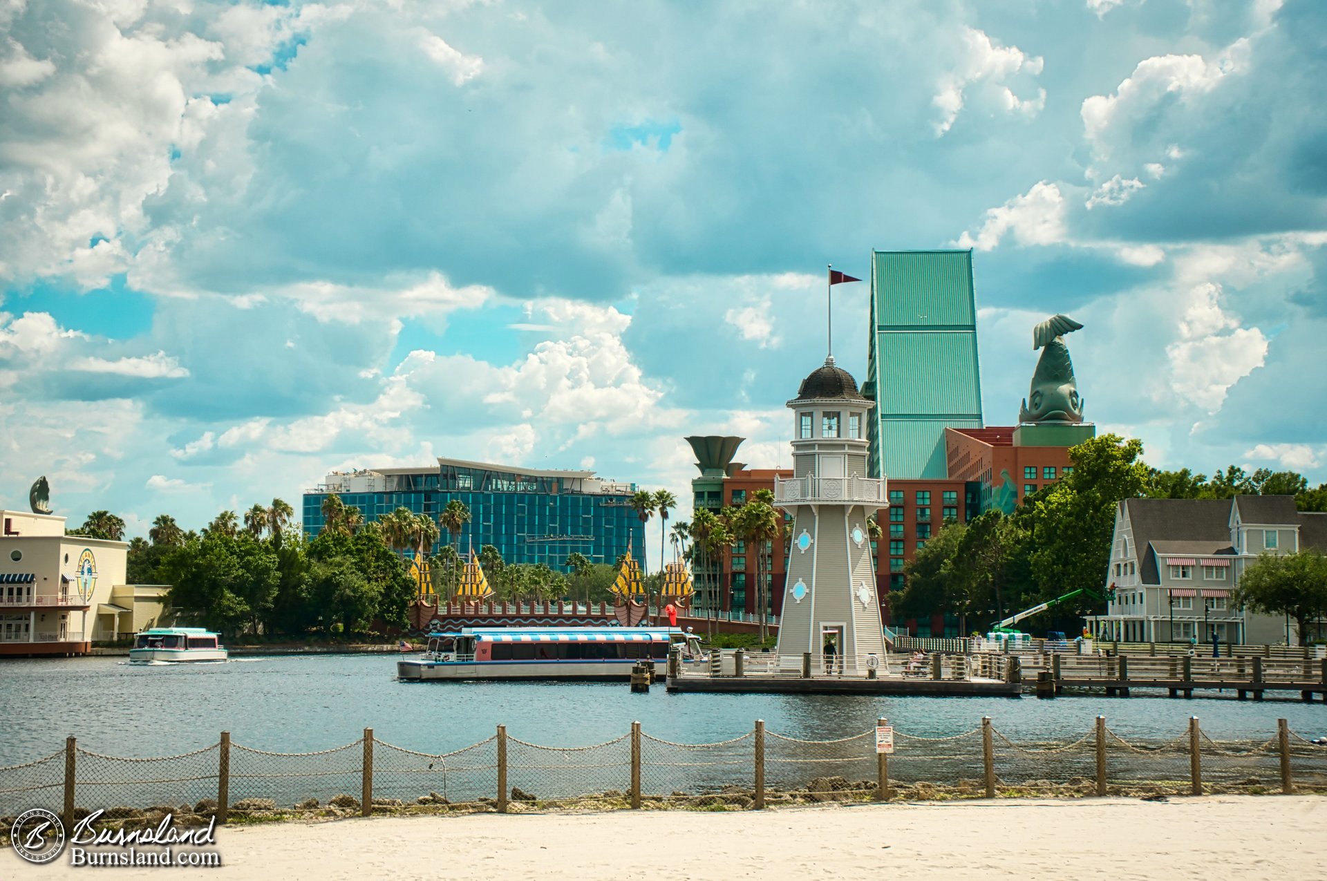 Lots of Epcot Resorts to see in this photo: The Lighthouse and the Yacht Club at the right, the Boardwalk at the left, the Walt Disney World Dolphin in the back right, the still-under-construction Swan Reserve farther in the background, and two Friendship boats. Plus, if you look closely, you can see one of the swan statues from the Walt Disney World Swan at the left, too.