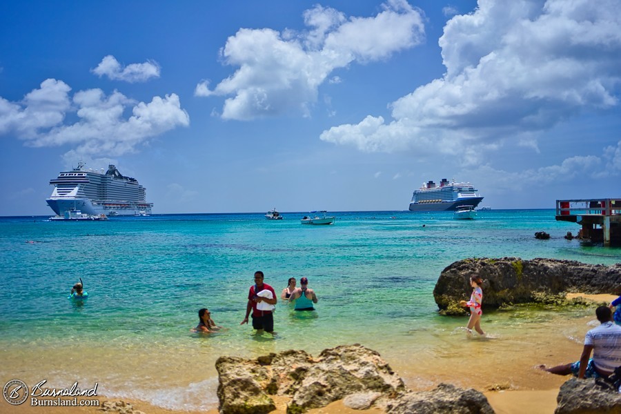 A beach in George Town, Grand Cayman, with cruise ships in the distance