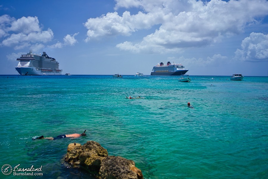 A beach in George Town, Grand Cayman, with cruise ships in the distance