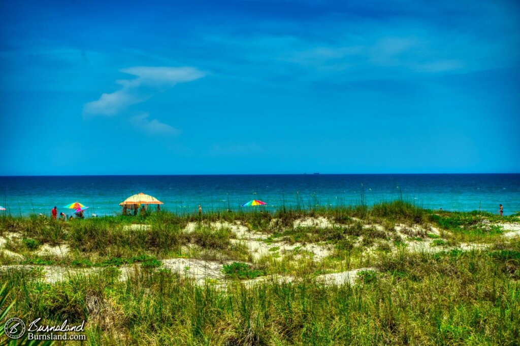 A view of the beach and the ocean beyond from across the dunes at Lori Wilson Park in Cocoa Beach, Florida.