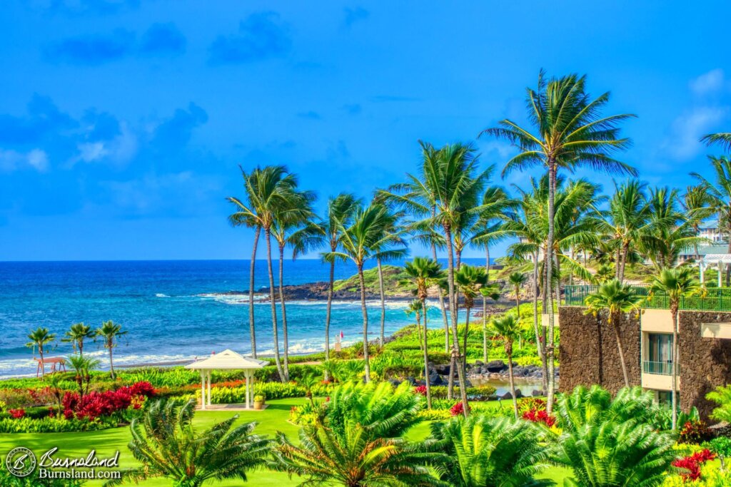 Waves in the Pacific Ocean break onto the shore past the Grand Hyatt resort on the island of Kauaʻi in Hawaiʻi