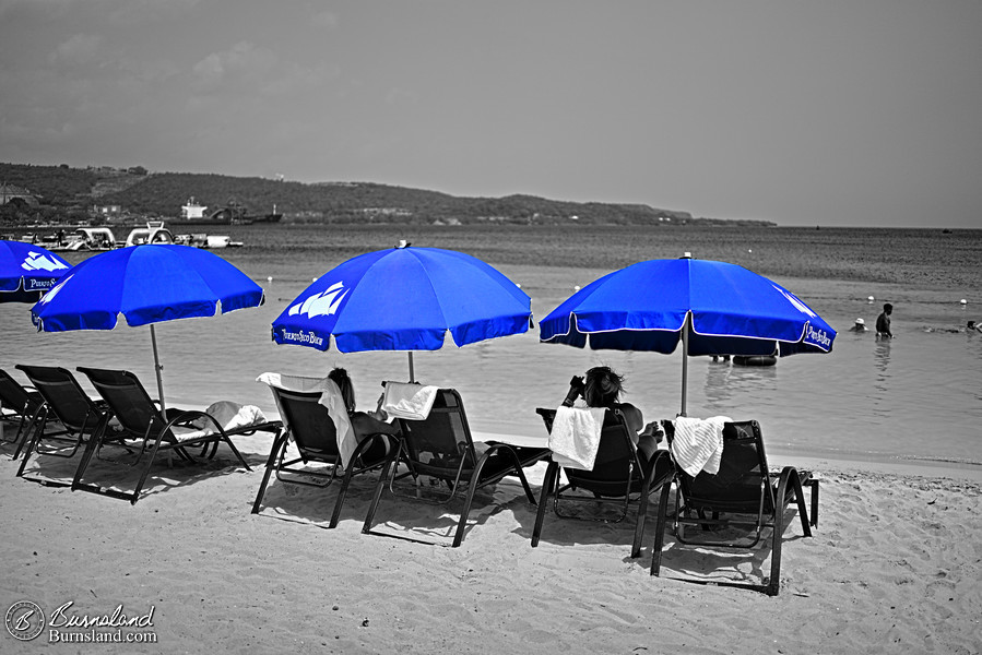 People lounge under blue umbrellas at Puerto Seco Beach Park in Discovery Bay, Jamaica, as seen during our June 2022 Disney Cruise