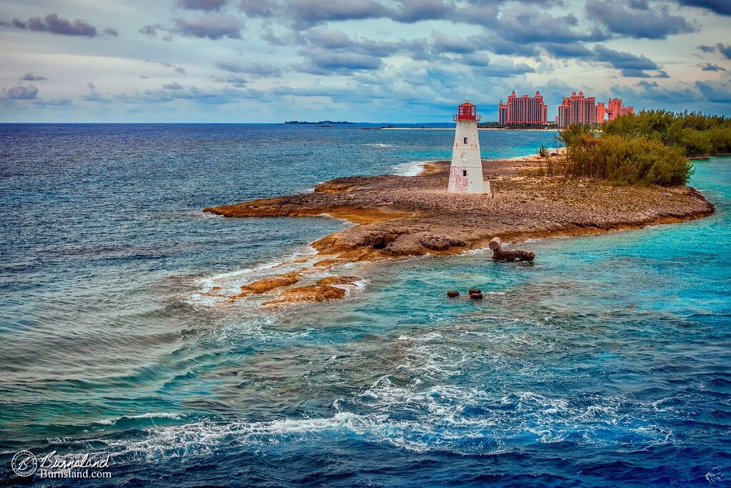 Blue water fills the harbor in Nassau, Bahamas, with a lighthouse and the Atlantis resort in the distance. Read all about it at Burnsland!