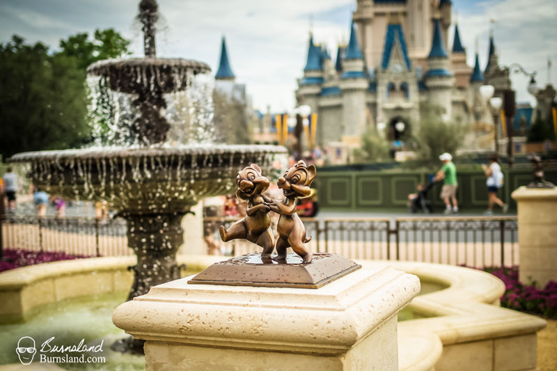 A statue of the chipmunks Chip N Dale is found in the Central Plaza of the Magic Kingdom at Walt Disney World, with Cinderella Castle in the background.