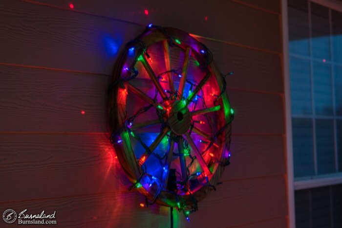 A lighted wagon wheel for Christmas on our front porch