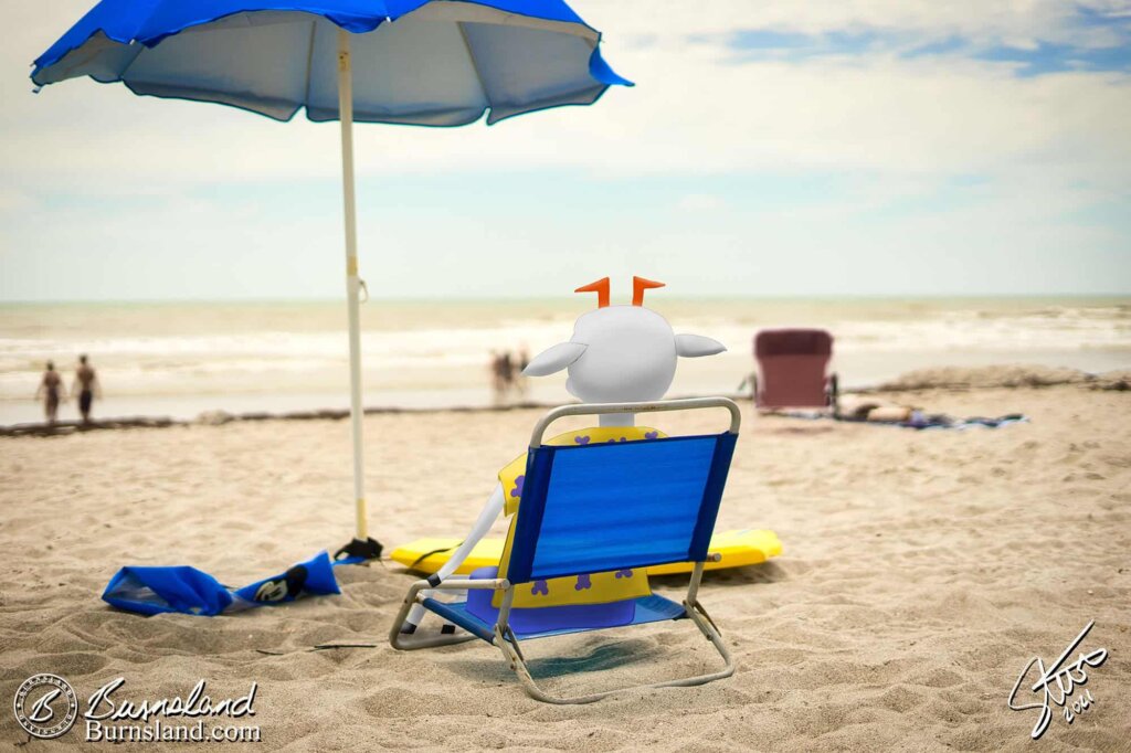 Mobius the Goat relaxes in a beach chair with his hooves in the sand at Cocoa Beach, Florida, almost as though he were on our vacation.