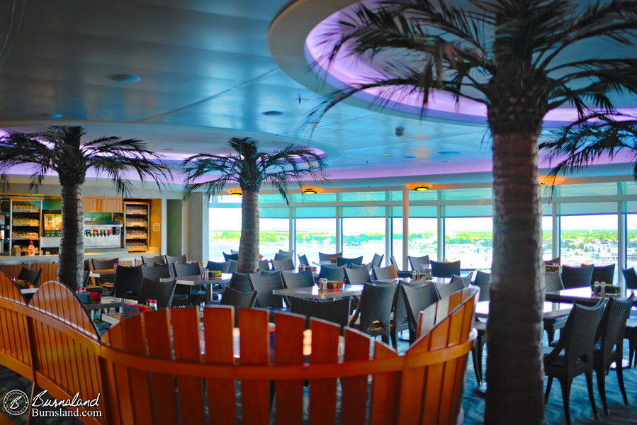 Palm trees and wooden seats inside the Cabanas buffet on the Disney Fantasy cruise ship