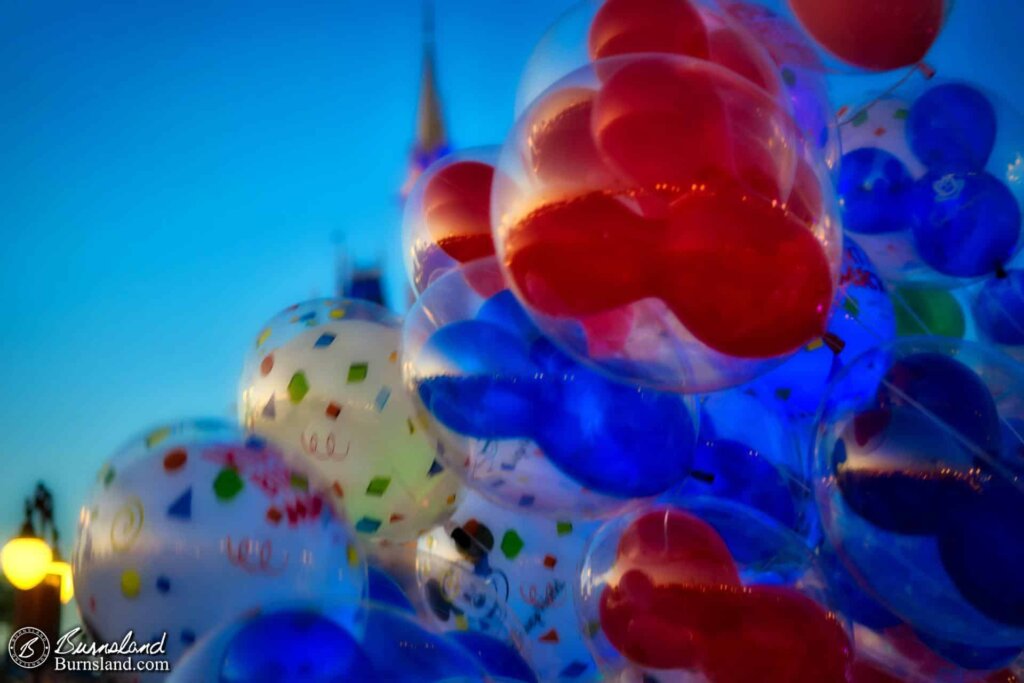 Balloons float through the evening sky in the Magic Kingdom at Walt Disney World