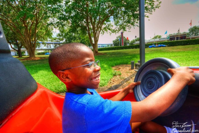 Jaylin behind the wheel on the Tomorrowland Speedway in the Magic Kingdom at Walt Disney World