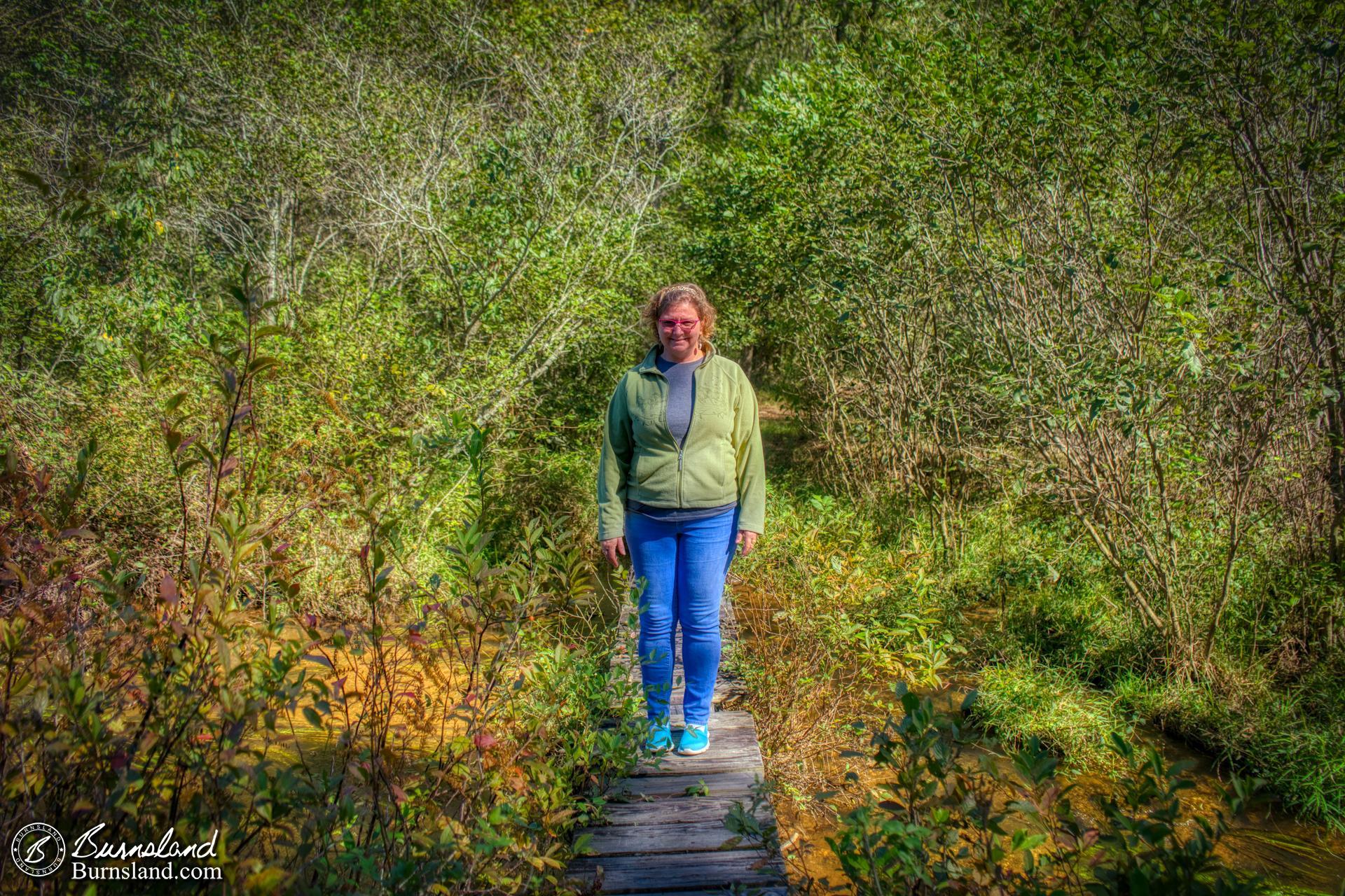 Laura crosses a small bridge at Wall Doxey State Park in Mississippi on a fall day