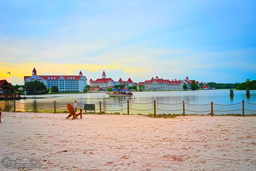 The Grand Floridian Resort and a passing boat are seen across Seven Seas Lagoon at Walt Disney World during our July 2022 Florida Trip.