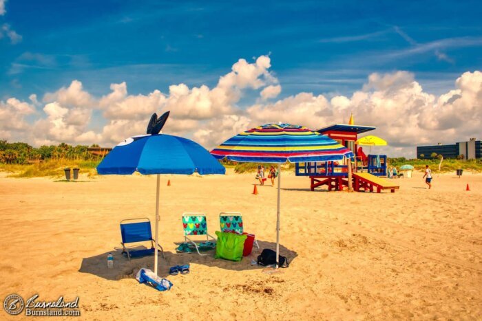 Our umbrellas and the rest of our beach stuff in the sand at Lori Wilson Park in Cocoa Beach, Florida