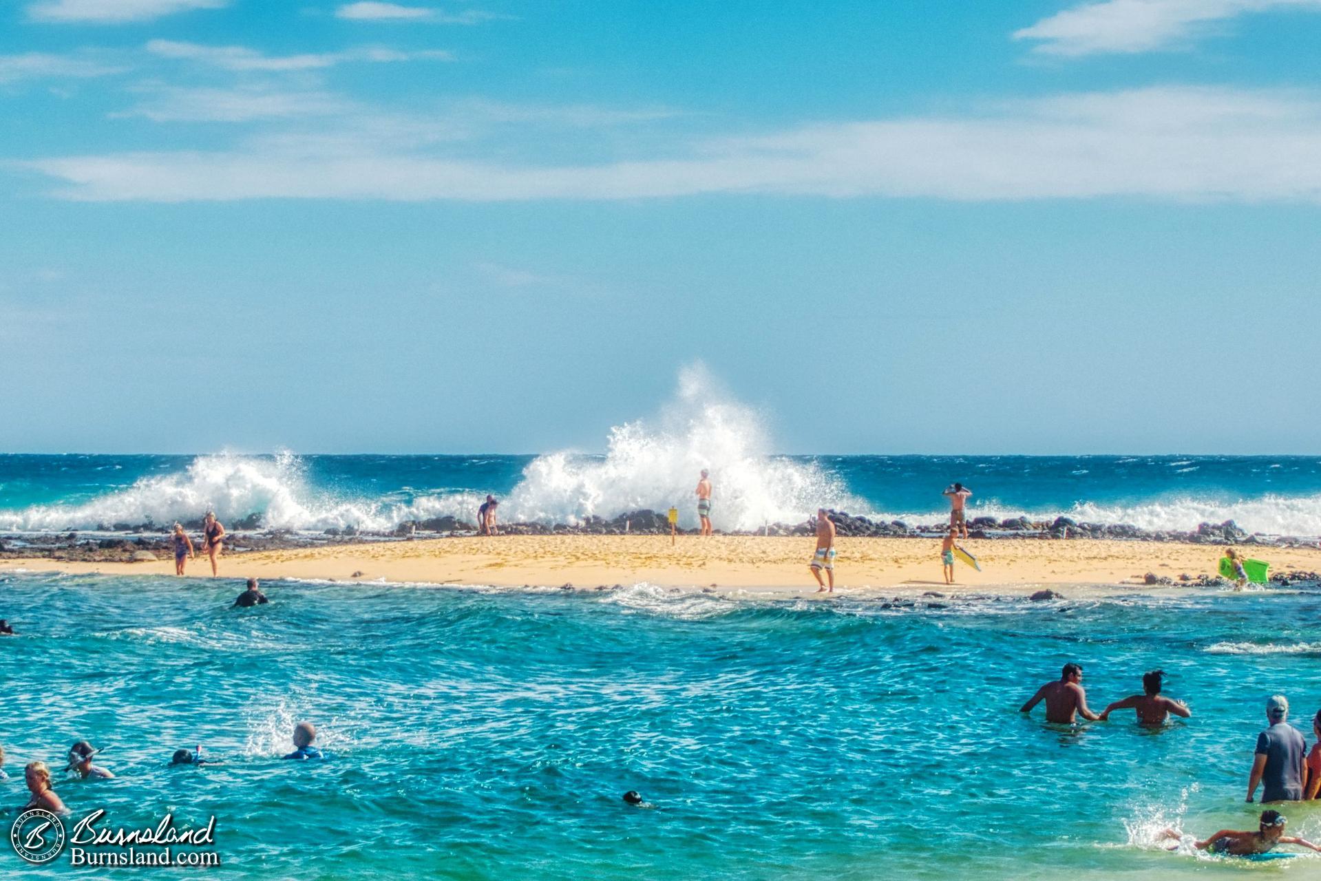 Waves crash onto the shore at Poʻipū Beach Park on the island of Kauaʻi in Hawaiʻi