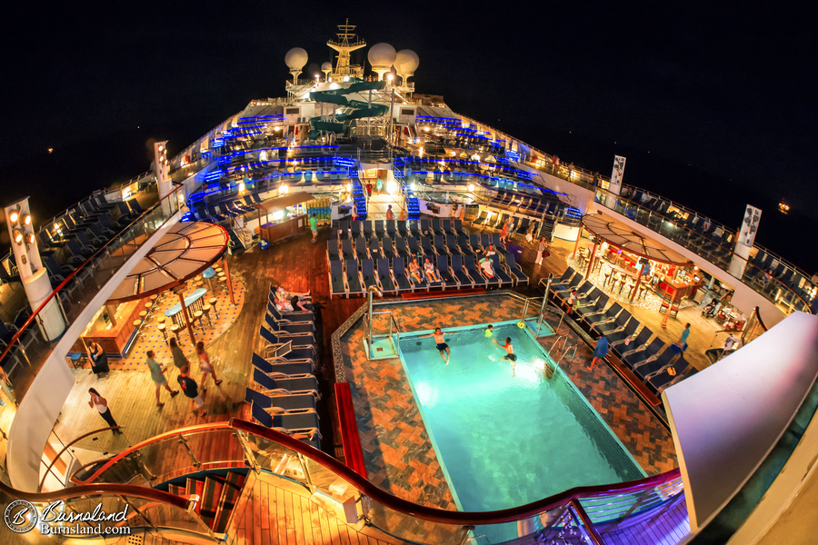 The pool decks of the Carnival Liberty cruise ship are filled with light, but not filled with people, late at night. Read all about it at Burnsland.