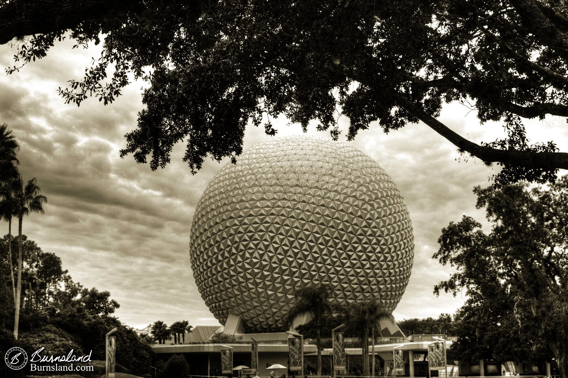 Spaceship Earth  is framed by trees in this view from outside of the entrance of Epcot at Walt Disney World in Florida.