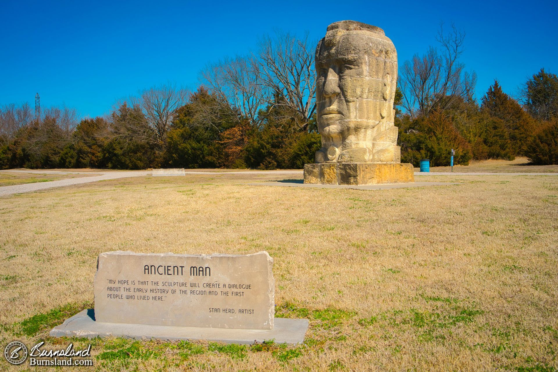 A large stone “Ancient Man” statue by artist Stan Herd in a park in Parsons, Kansas