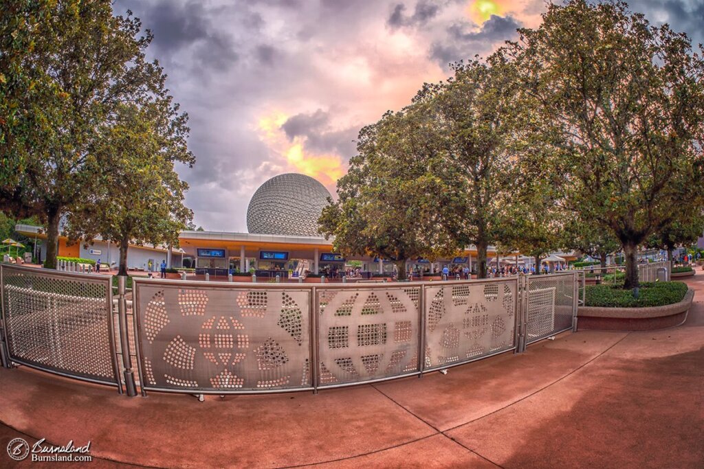 Gates outside of Epcot at Walt Disney World feature some old EPCOT Center designs, as storm clouds brew over Spaceship Earth in the distance. Read all about it at Burnsland!