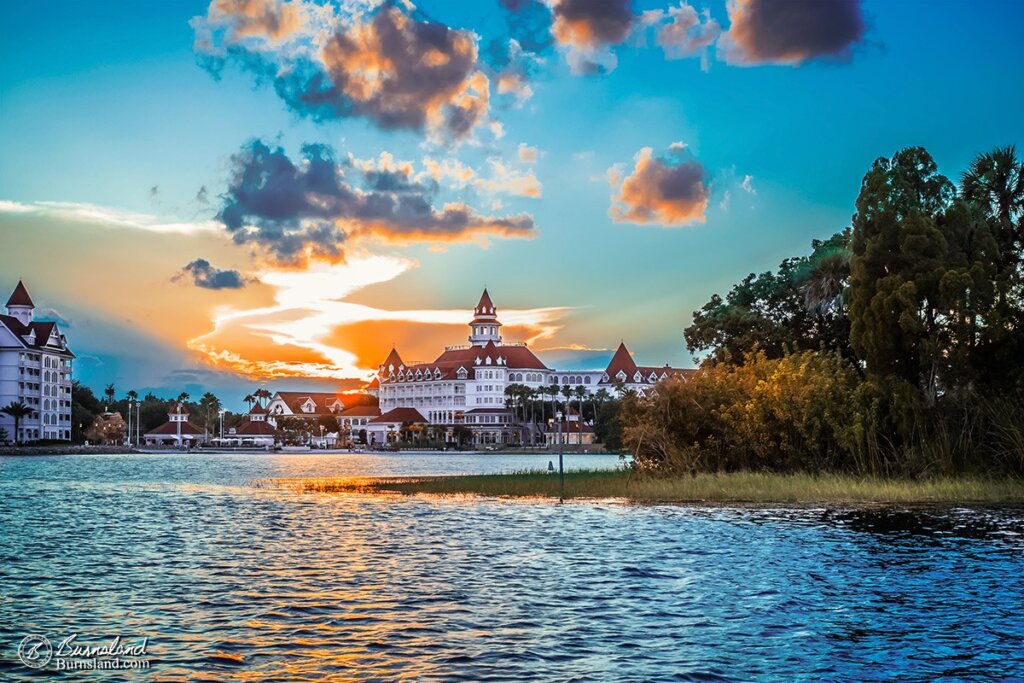 The sun sets behind the Grand Floridian Resort at Walt Disney World, lighting up the clouds that are starting to fill the sky, as seen across the waters of Seven Seas Lagoon. Read all about it at Burnsland!