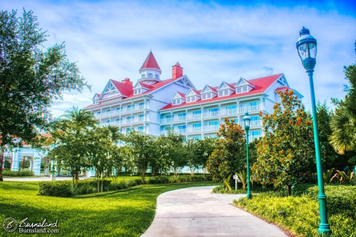 A walkway lined with green grass and trees leads to the Grand Floridian Resort at Walt Disney World, as seen during our 2019 Florida Summer Vacation