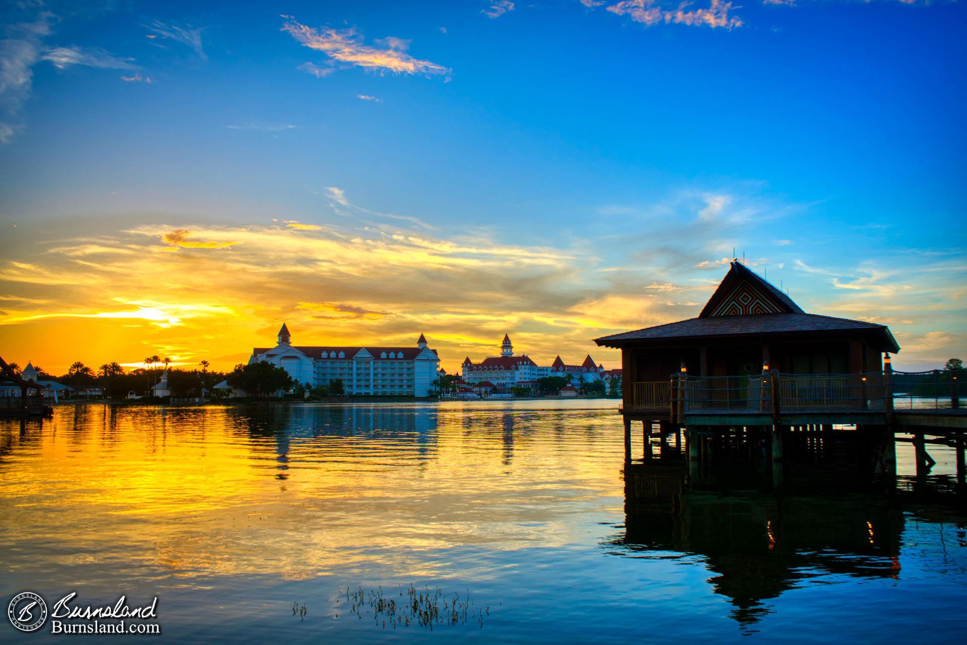 The sun sets over Seven Seas Lagoon at Walt Disney World as seen from the beach at the Polynesian Village Resort