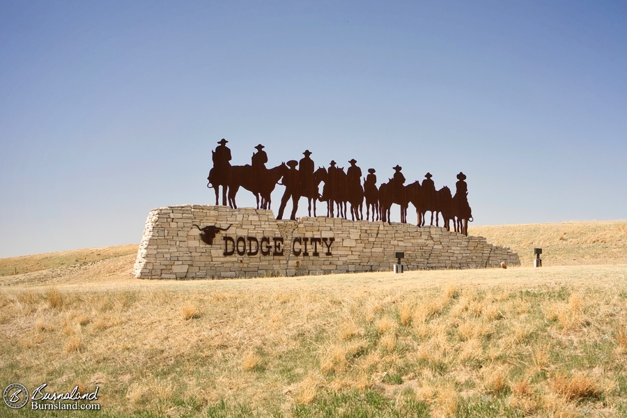 A sign with cobowys welcomes us to Dodge City, Kansas